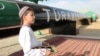 Turkmenistan -- A Turkmen boy in traditional dress waits for the president at an official launch ceremony for the East-West gas trunk pipeline in Shatlyk, May 31, 2010