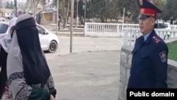Көшеде кетіп бара жатқан ниқаб киген әйел мен орамал тартқан оқушы қыз. Ақтөбе қаласы Жібек жолы ықшамауданы, 6 қазан, 2023 жыл.