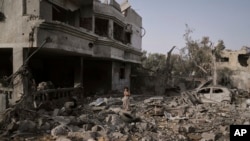Një vajzë palestineze qëndron mbi rrënojat e shtëpisë së familjes që u shkatërrua nga sulmet ajrore izraelite në Rripin e Gazës, 1 korrik 2025.