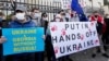Грузинські активісти тримають плакати на акції з підтримки України перед посольством України в Тбілісі. Грузія, 23 січня 2022 року